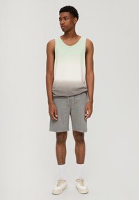 Groene naar grijze gradient tanktop, grijze shorts, witte sokken en beige sneakers. Casual pasvorm, katoenmateriaal, eenvoudig ontwerp en geen patronen.