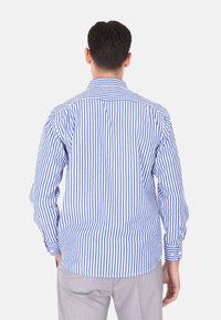 Camicia a maniche lunghe blu e bianca a strisce con colletto classico, vestibilità slim e polsini con bottone. Presenta un orlo curvo e una yoke posteriore.