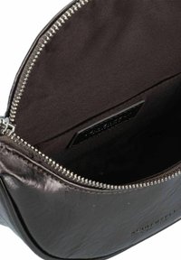 Borsa in pelle marrone con un esterno testurizzato, zip argentata e fodera in tessuto scuro. L'interno contiene un'etichetta di marca in rilievo.