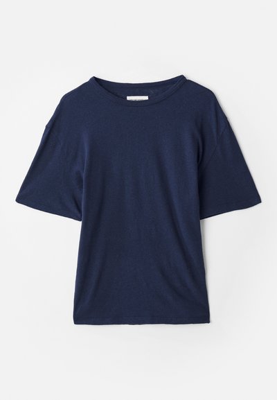 T-shirt oversize bleu marine en tissu doux, avec un col rond et des manches courtes, offrant une coupe décontractée. Aucun motif ou accent visible.
