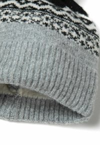 Pilkas megztas džemperis su raukšlėta apatine dalimi ir raštuota juosta, kurią puošia juodos ir baltos geometrinės figūros. Minkšta vilnos medžiaga.