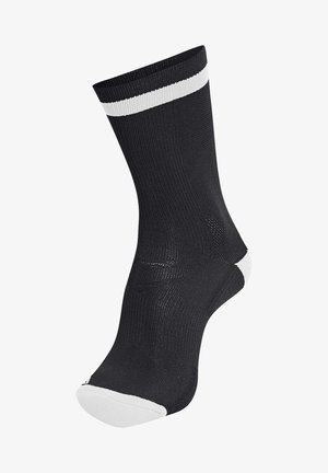 Sort atletiksok med ribbet tekstur, med en hvid stribe øverst og en hvid detalje på tåen. Mellemlang længde op til læggen.