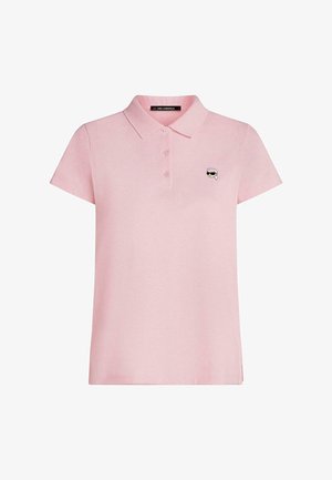 Polo rose clair à manches courtes avec trois boutons et petit logo représentant un visage avec des lunettes de soleil sur la poitrine gauche.