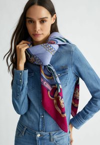 Sciarpa a fantasia viola e rossa con accenti dorati, caratterizzata da design astratti e una consistenza setosa, avvolta in modo elegante attorno al collo.