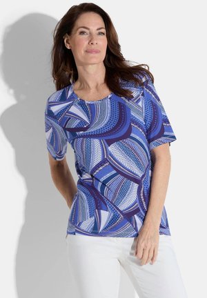 Haut à manches courtes bleu à motifs avec divers designs géométriques, agrémenté d'accents blancs et violets, fabriqué en tissu léger.