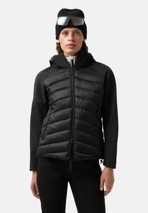 Veste noire zippée avec un design matelassé sur le torse, en tissu léger, capuche ajustable et silhouette épurée.