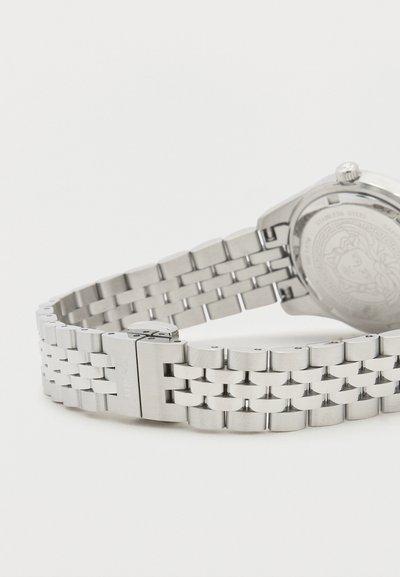 Hõbedane roostevabast terasest käekell detailselt mustrilise link-rihmaga ja ümmarguse sihverplaadiga, millel on kroon ja graveeritud tagumine külg.