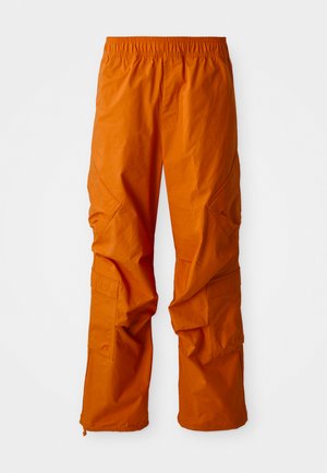 Pantalons cargo orange avec taille élastique, dotés de poches latérales et d'une coupe décontractée. Fabriqués en tissu léger, avec une texture douce.