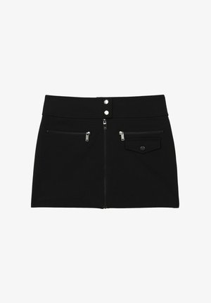 Čierna sukňa z pevnej tkaniny, s dvoma zipsovými vreckami, horizontálnym zipsovým uzáverom a dvojitými cvokmi v páse.