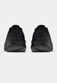 Μαύρα αθλητικά παπούτσια με επενδυμένο κολάρο, υφή στην επάνω επιφάνεια και κυρτή σόλα. Σημαντική ραβδωτή λεπτομέρεια στη φτέρνα και λείο φινίρισμα.