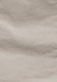 Beige kangas, jossa on pehmeä ja sileä tekstuuri; hienoinen kiilto sekä hienovaraisia aaltoja ja taitoksia pinnalla, luoden lempeän aaltoilevan kuvion.