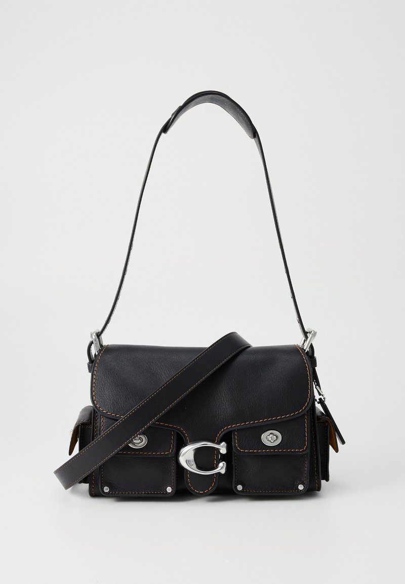 Sac en cuir noir à bandoulière avec un rabat, deux poches avant, des coutures marron, quincaillerie en argent et une seule sangle réglable.