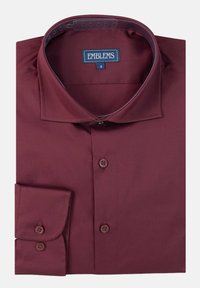 Camisa burdeos de botonadura frontal con cuello estructurado y mangas largas, que presenta puños con dos botones y una tela suave y texturizada.