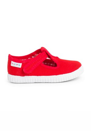 Scarpa di tela rossa con cinturino a strappo, suola in gomma bianca e motivo testurizzato circolare. Presenta una fodera a scacchi e un'etichetta di branding.