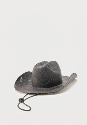 Black woven cowboy hat with a curved brim and an adjustable chin strap resting on a white surface.