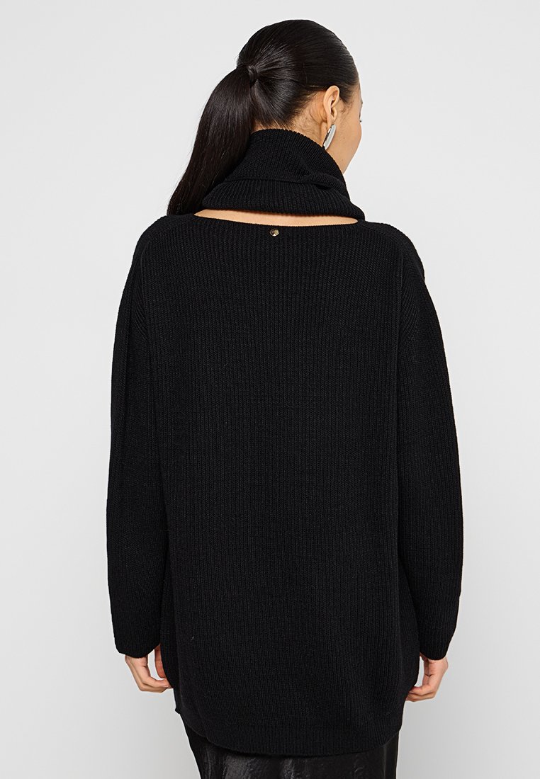 Schwarzer Strickpullover mit hohem Kragen, offenem Rückendesign und einem goldenen Akzent am Halsauschnitt. Verziert mit Rippstruktur und langen Ärmeln.