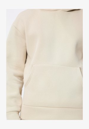 Sweat à capuche beige en tissu doux. Comprend une poche kangourou frontale et des poignets et ourlet côtelés. Texture lisse et mate.