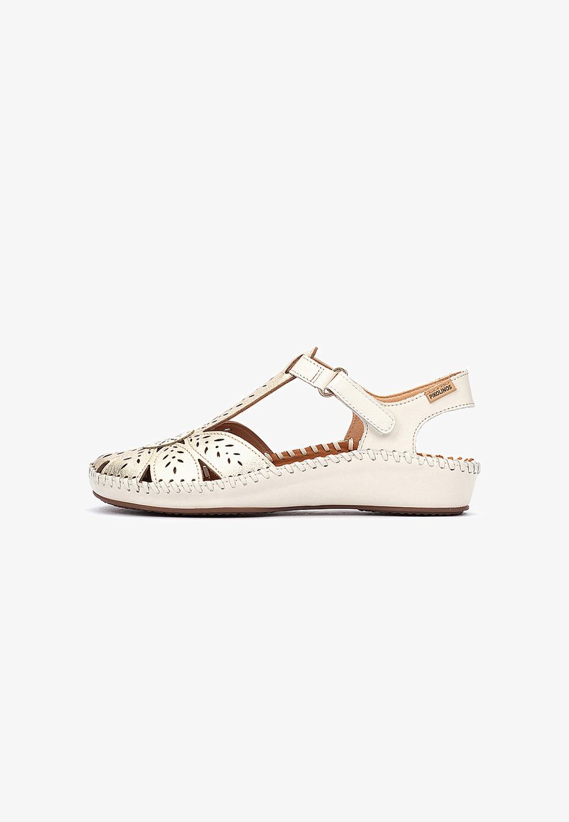Sandale pour femme en cuir blanc cassé avec lanière en T, fermeture à velcro à la cheville, découpes florales et semelle compensée cousue.
