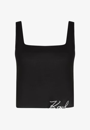 Črna majica brez rokavov z kvadratnim izrezom in širokimi naramnicami, ki se ponaša z gladko teksturo in belim vezenim detailom "Karl" na robu.