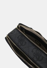 Portafoglio nero con zip, superficie testurizzata e hardware in tonalità oro. Presenta numerosi scomparti per l'organizzazione. Interno foderato in beige.