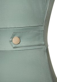 Svijetlozeleni materijal za haljinu s glatkom teksturom, s dekorativnim dijagonalnim šavom i okruglim metalnim gumbom kao dodatkom.