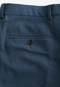 Navyblaue Hose mit glatter Textur, Standardbund, Gesäßtasche mit Knopfverschluss und subtilen diagonal gewebten Muster.