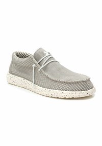 Zapato de punto gris con parte superior texturizada, cordones blancos y suela blanca moteada. El interior presenta un sutil patrón de rayas.