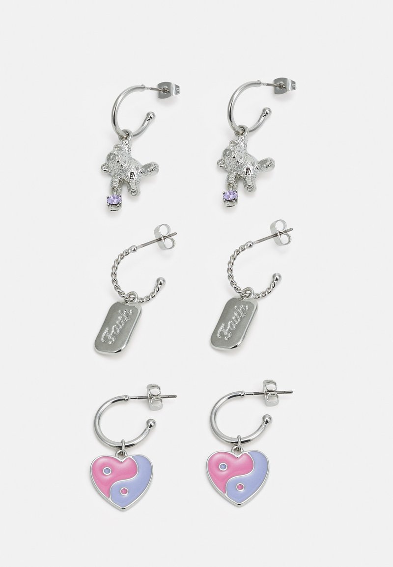 Conjunto de quatro brincos: dois brincos de argola em prata com pendentes de urso, um com uma gema roxa; dois com um design de coração yin-yang em rosa e azul.
