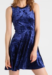 Sukienka z granatowego weluru bez rękawów z rozkloszowanym dołem, z okrągłym dekoltem i miękką fakturą.