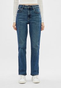 Jeans din denim albastru cu talie înaltă, cu o croială dreaptă, având buzunare frontale și închidere cu nasture. Textură netedă și detalii clasice de cusătură.