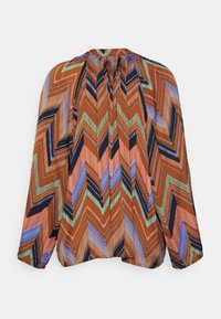 Blouse multicolore avec un motif en chevrons marron, bleu, vert et noir, dotée de manches longues et d'un dos plissé.