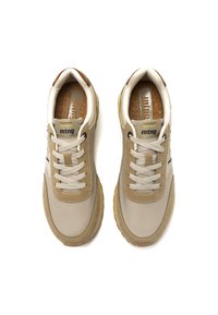 Zapatillas deportivas beige con una parte superior texturizada, cordones claros y un acento de cuero marrón. Suela de goma para mayor tracción. Logotipo de la marca en la lengüeta.