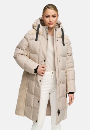 Beige gewatteerde jas met een bontaccent, voorzien van een capuchon, vooraan rits, drukknoopsluiting en contrasterende zwarte banden. Glad textuur, middellange stijl.