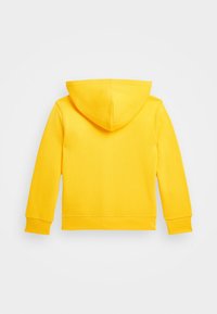 Gul huvtröja med långa ärmar, gjord av mjukt bomullsmaterial. Har en stor huva samt ribbade muddar och fåll.