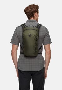 Grüner, leichter Rucksack mit schlichtem Design, verstellbaren Trägern und einem Frontlogo. Strukturiertes Material mit einem Reißverschlussfach.