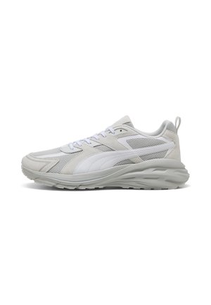 Zapatilla deportiva gris claro con franja lateral blanca, parte superior de malla y ante, suela acolchada y tira para tirar en el talón.