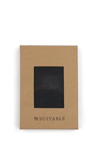 Bruin kraftpapierdoos met een doorzichtig venster dat een zwart item binnenin toont. Heeft het woord "GESCHIKT" gedrukt in een helder, donker lettertype.