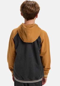 Sweat à capuche avec un corps gris et des manches moutarde. Doté d'un ourlet et de poignets côtelés avec des rayures blanches. Tissu doux et design décontracté.