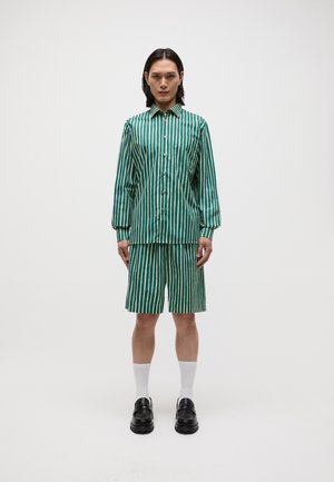 Green striped button-up shirt with long sleeves paired with matching shorts, featuring light and dark green stripes, worn with black shoes.
