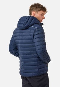 Navy blauwe pufferjack met horizontale stiksels, een capuchon en een logo op de schouder. Glad textuur, ontworpen voor warmte en comfort.
