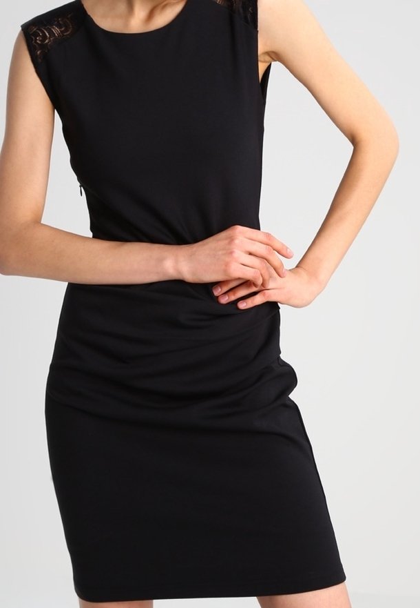 Černé bezramínkové šaty s přiléhavým střihem, zdobené krajkovými detaily na ramenech a nařasenou texturou kolem pasu.