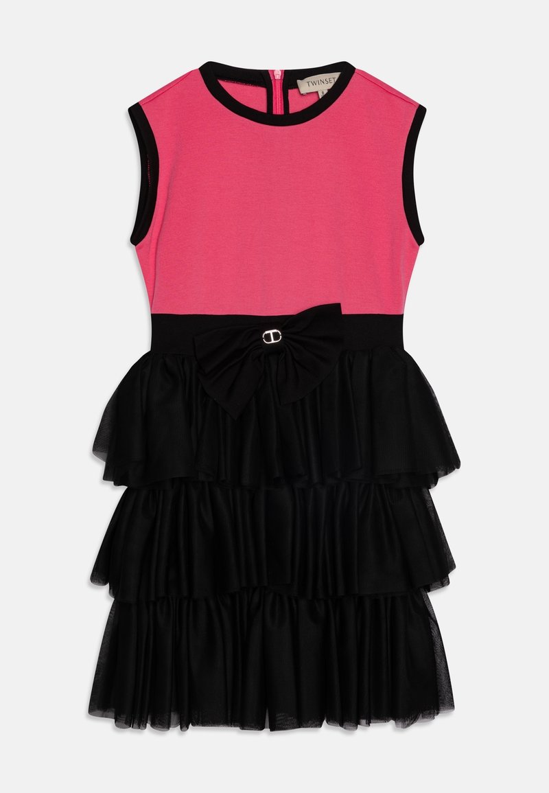 Robe sans manches avec corsage rose ajusté, bordure noire, ceinture noire avec nœud et jupe noire à volants superposés.