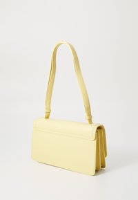 Yellow leather handbag with a structured design, flat top, and adjustable strap. Features a smooth texture and clean, minimalist lines.