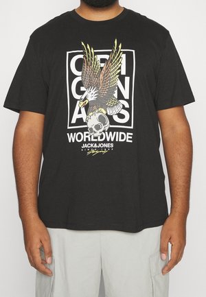 Black cotton t-shirt featuring a large graphic of an eagle above a skull, framed by the text "ORIGINALS WORLDWIDE" in white and yellow accents.