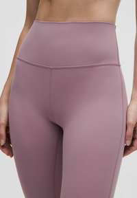 Magasan dérgó leggings puha málna színben, rugalmas anyagból készült, lapos varratokkal és látható minták vagy fém részletek nélkül.