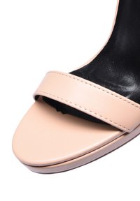 Sandalo con tacco alto beige caratterizzato da una fascia in pelle liscia e un interno nero, con punta rotonda e un design elegante e minimale.