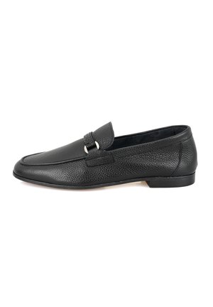 Black leather loafer with a textured finish, a rounded toe, and a decorative strap featuring silver hardware accents. Flat heel design.