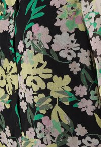 Blusa preta com flores apresenta flores amarelas e rosas, folhas verdes, fecho de botão e um tecido texturizado.