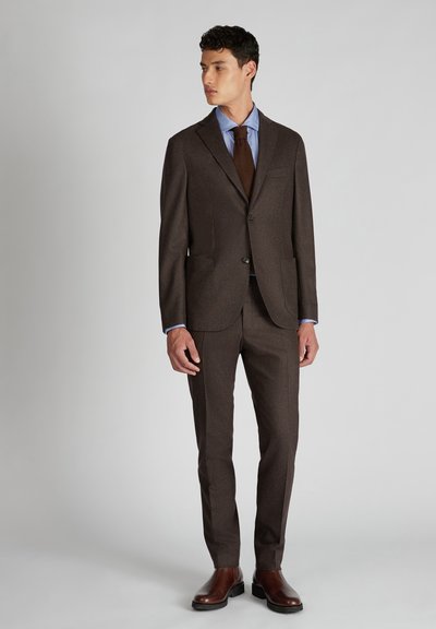 Completo marrone su misura con finitura texturizzata, una camicia azzurro chiaro e una cravatta marrone scuro. Dettagli notevoli includono la vestibilità slim e le scarpe in pelle liscia.
