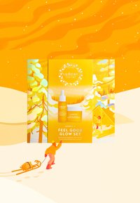 Le set Lumene Nordic-C Feel Good Glow présente un emballage jaune vif orné d'illustrations, comprenant un flacon compte-gouttes et une crème hydratante, tous deux visuellement attrayants.